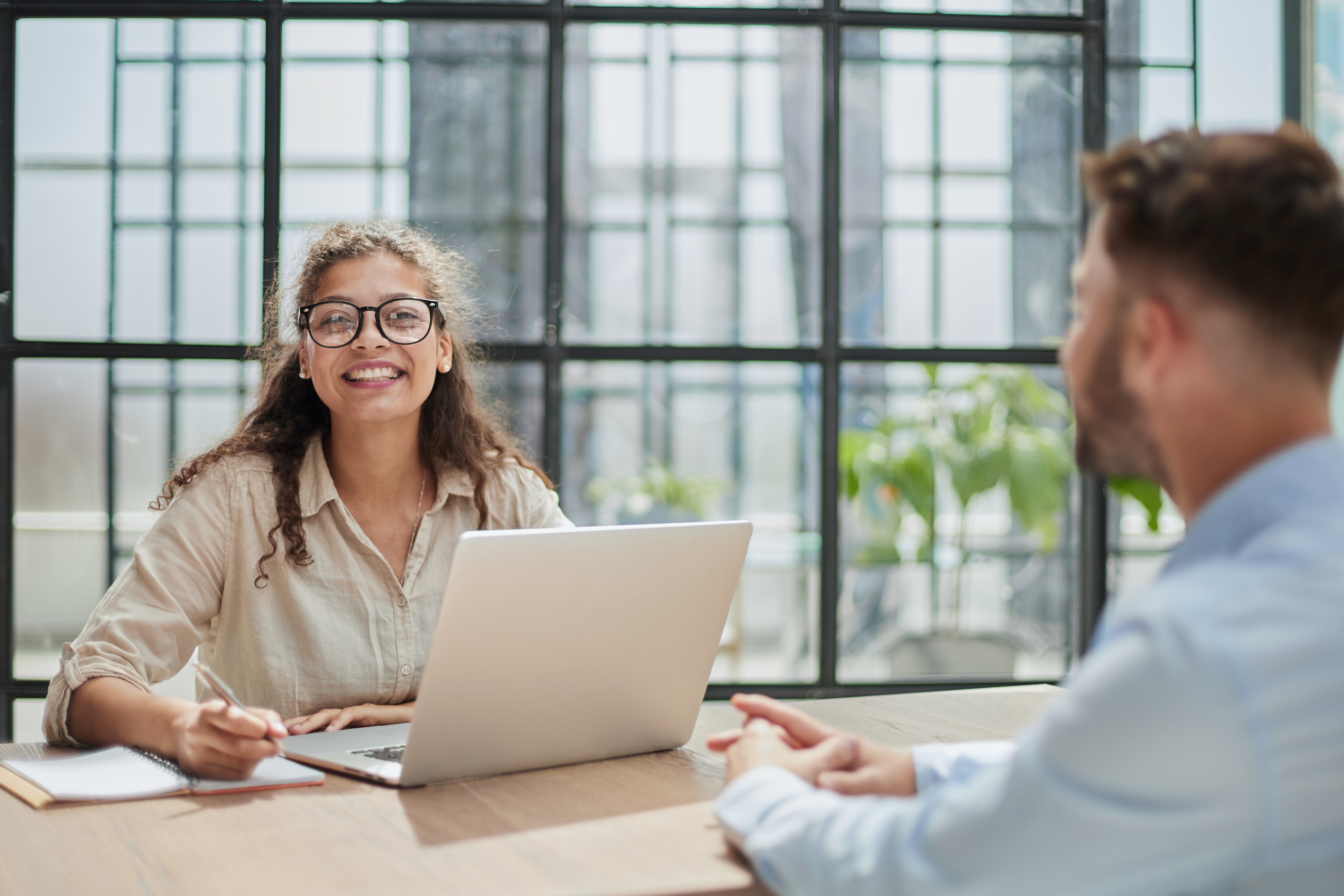 manager-glasses-sitting-table-receives-client-office