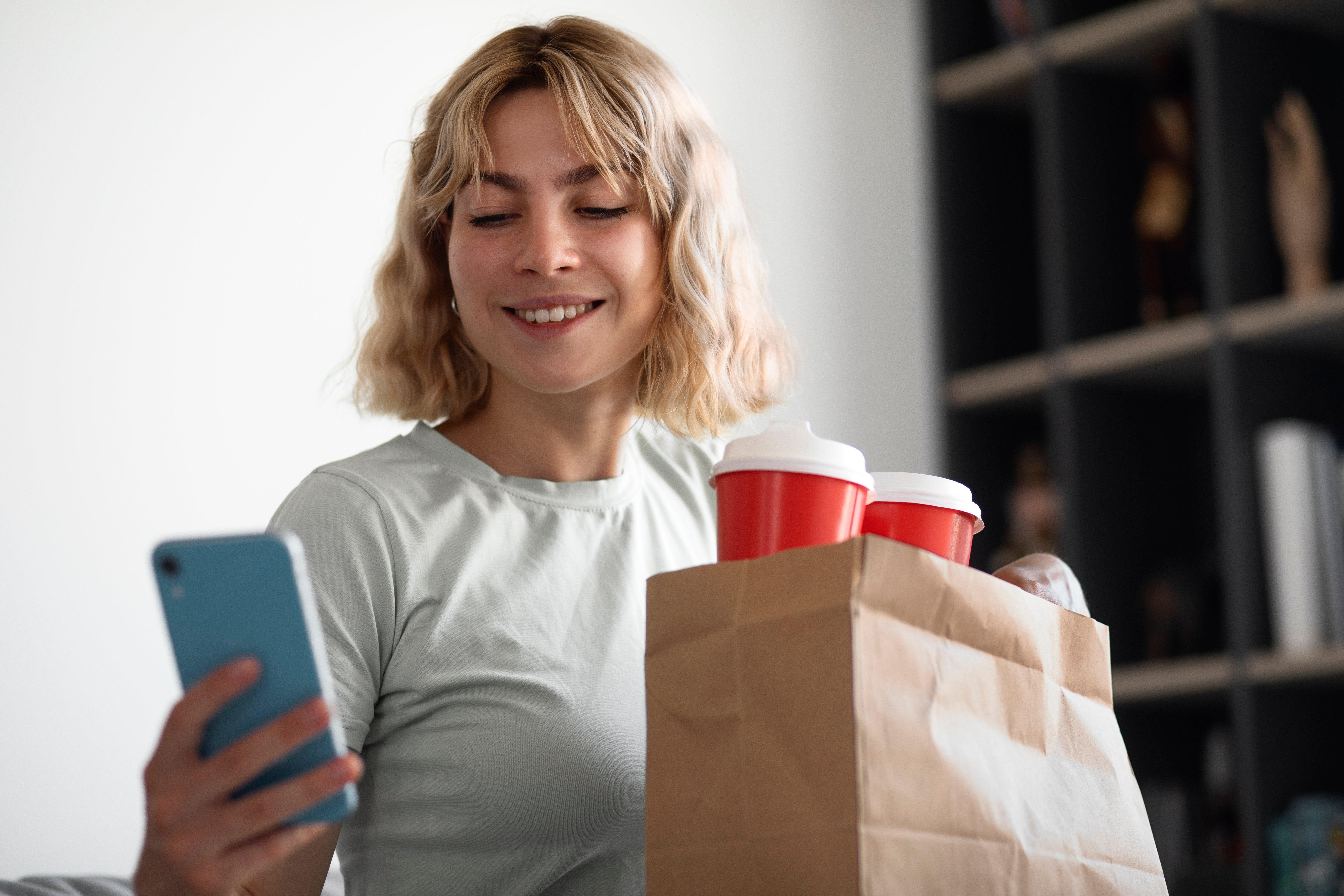medium-shot-smiley-woman-holding-smartphone