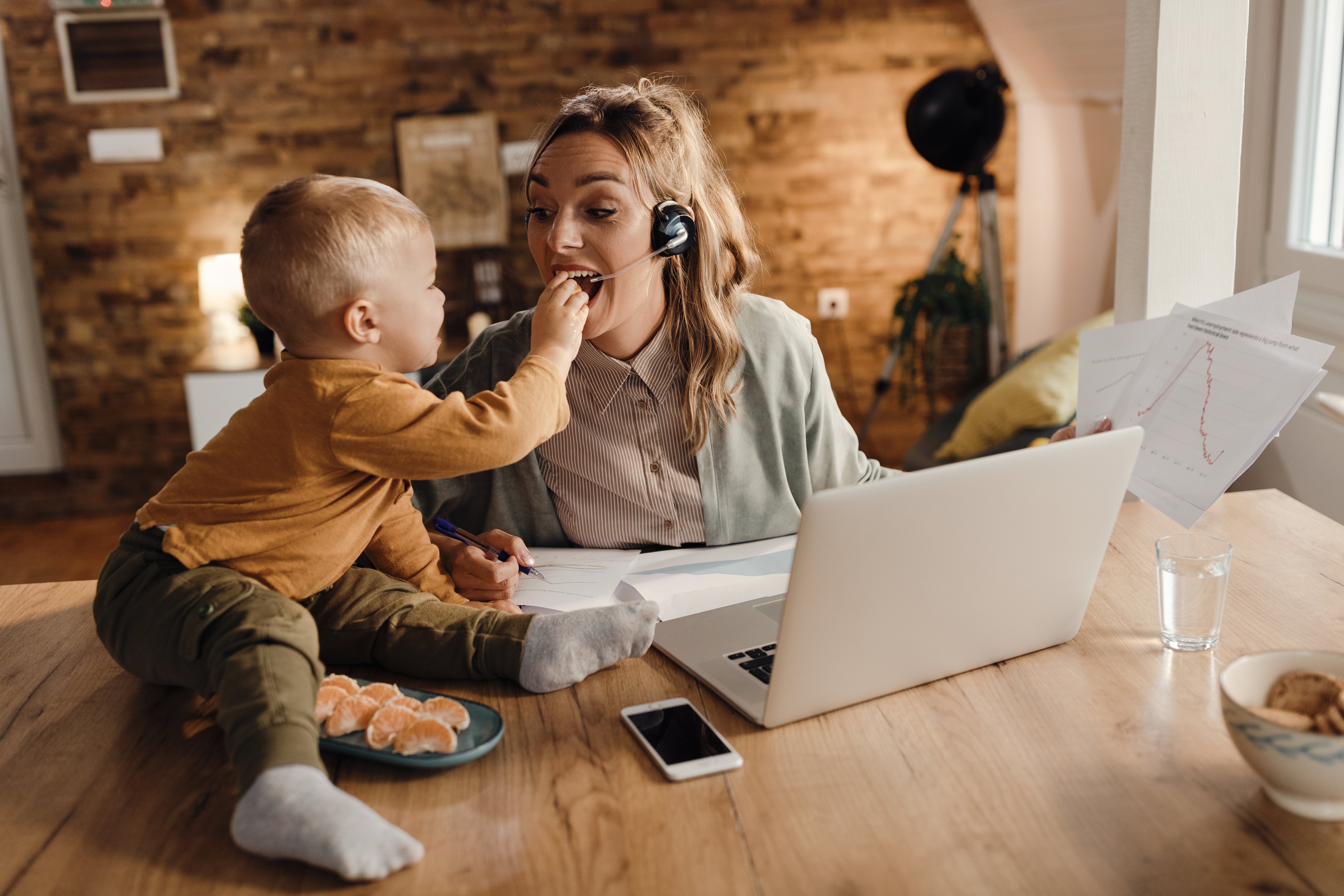 small-boy-feeding-is-mother-while-she-is-working-home
